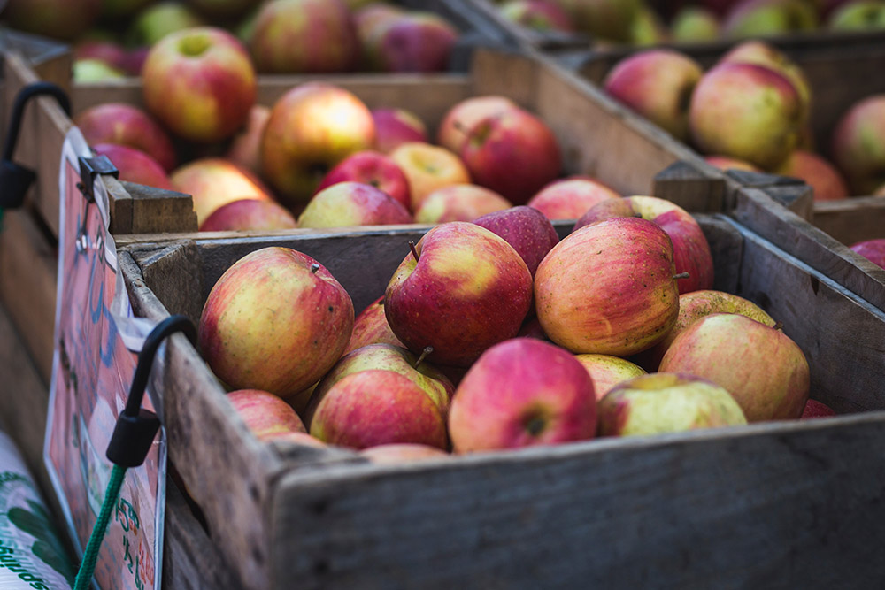 Große Äpfel in Obstkisten aus Holz auf einem Wochenmarkt