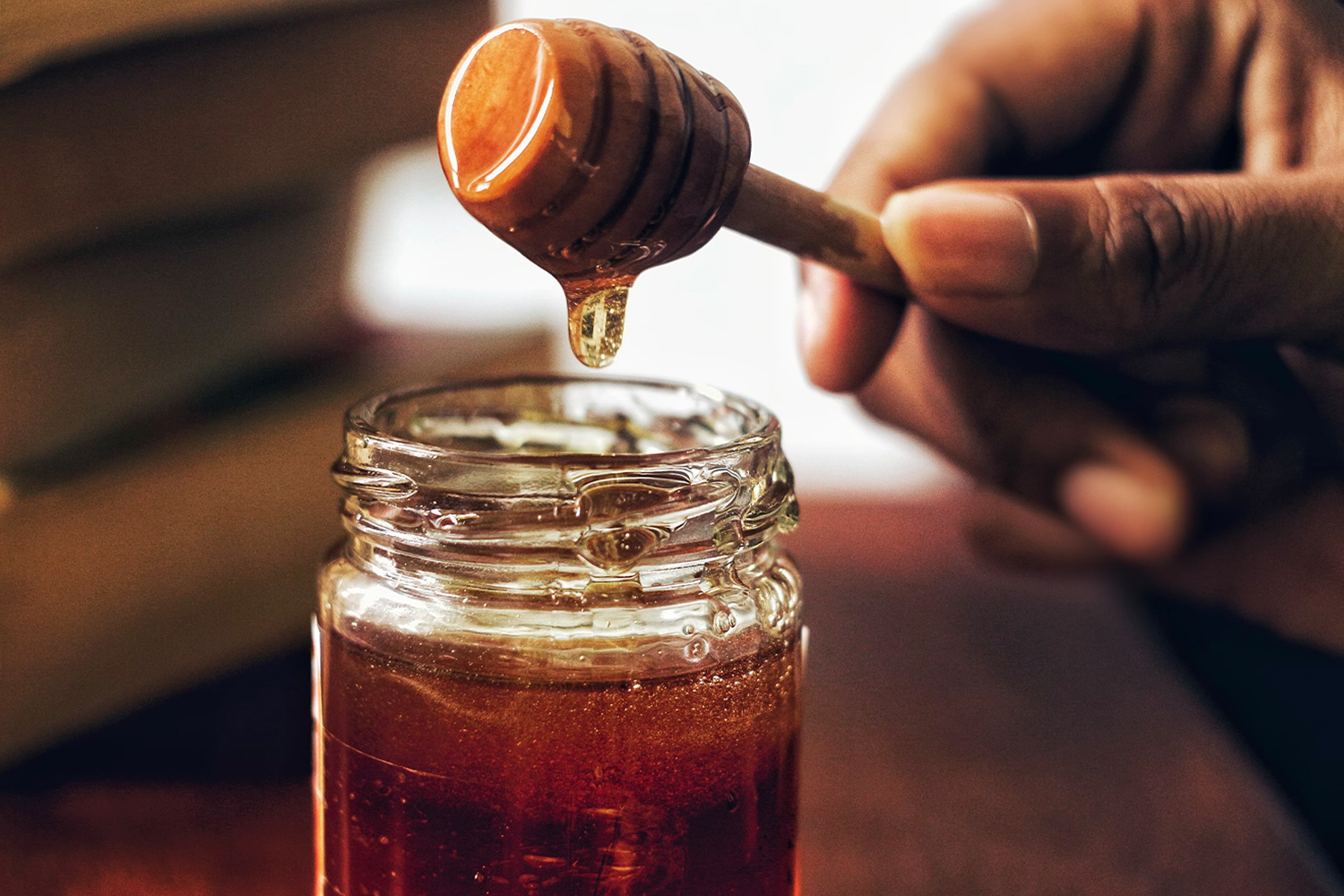 Ein Glas Honig mit einem Honigloeffel