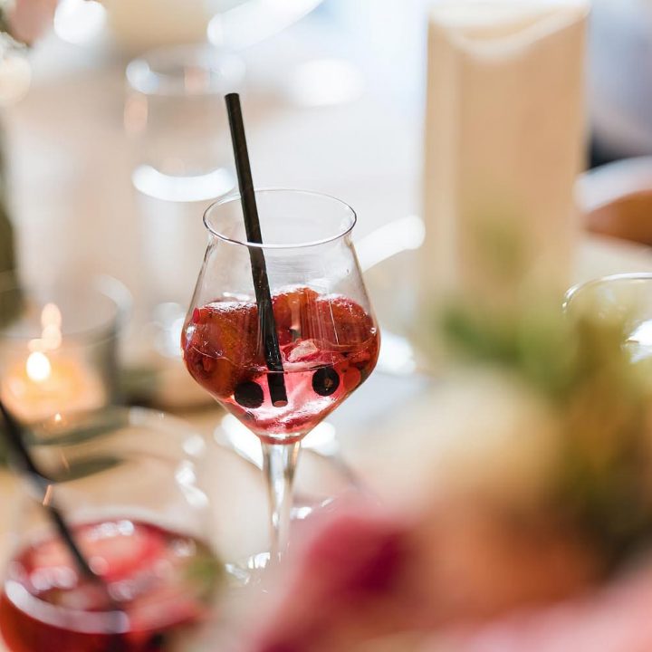 Zwei Lillet Wild Berry Cocktails auf einem Tisch, mit Strohhalmen und Beerenfrüchten serviert