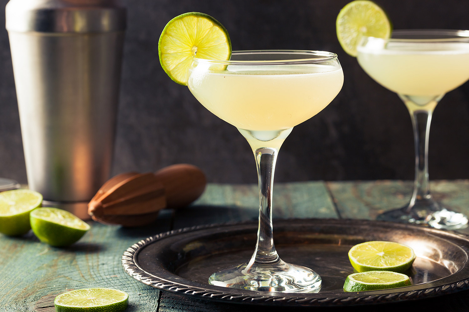 Margarita cocktails against dark background and garnished with lime slices