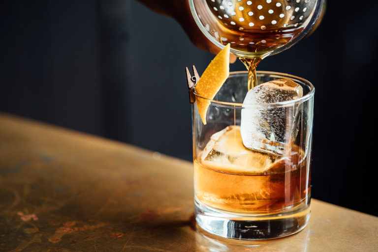 Old Fashioned Whiskey Cocktail in einem Tumbler-Glas und Eis