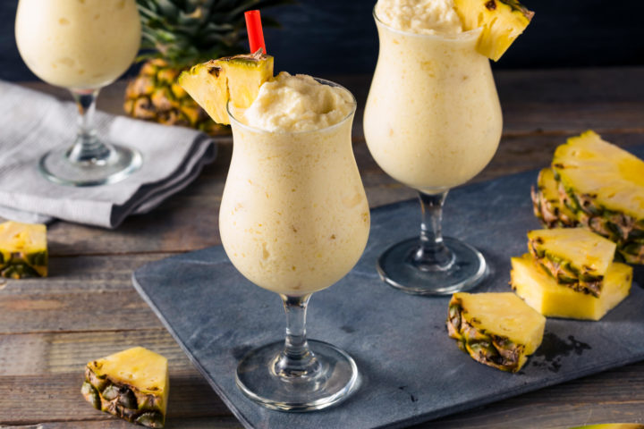 Piña Colada Cocktail mit Ananas garniert auf einer Schieferplatte