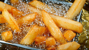 Goldbraune Pommes frites werden in heißem Öl frittiert