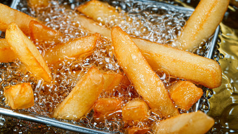 Goldbraune Pommes frites werden in heißem Öl frittiert