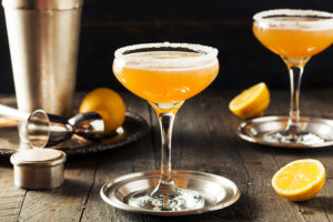Sidercar Cocktails mit Zuckerrand und Zitronen auf einem Untersetzer.