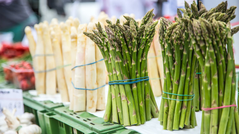 Grüner und weißer Spargel auf einem Wochenmarkt zum Verkauf aufgestellt